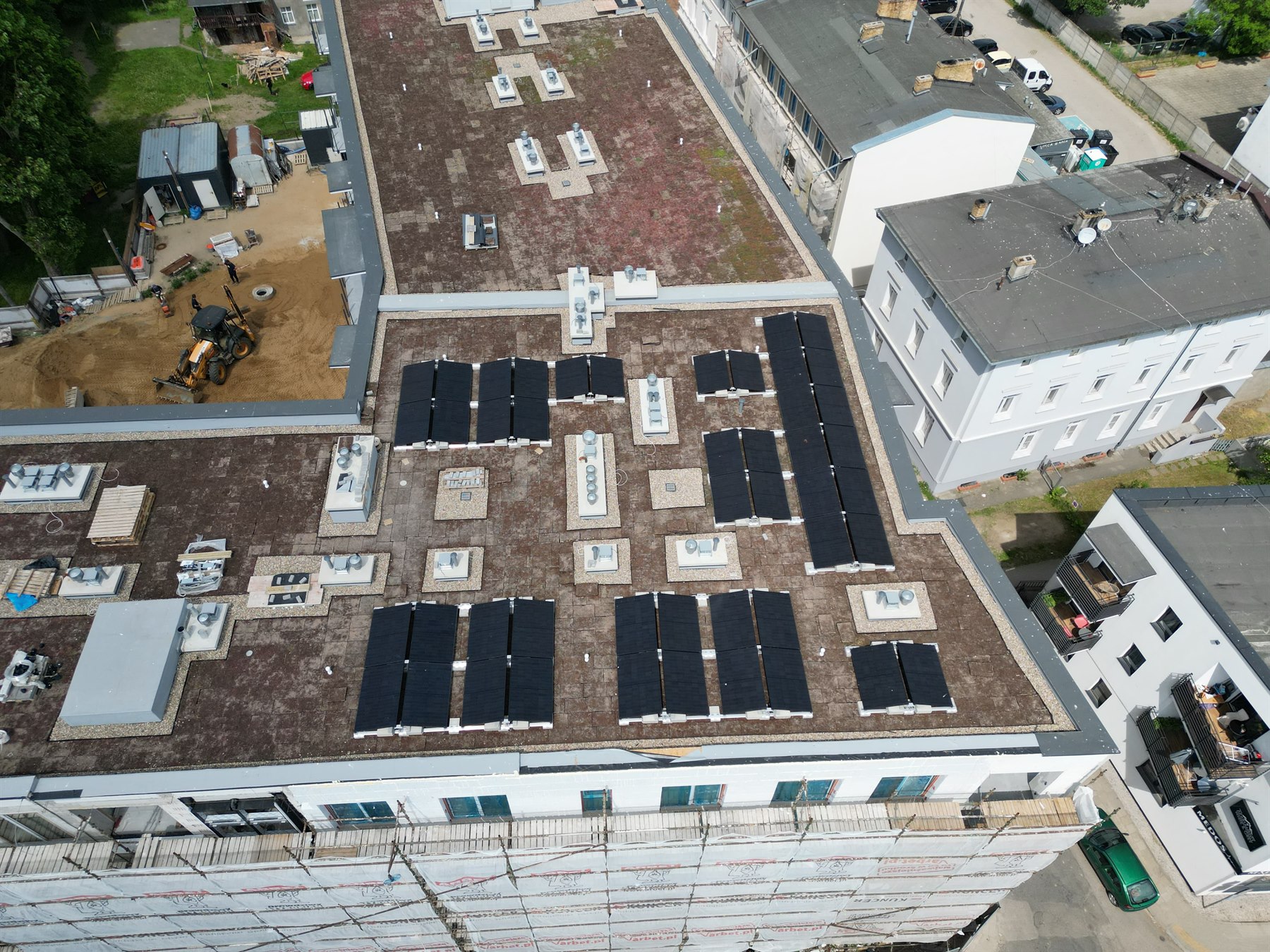 Nowoczesna instalacja fotowoltaiczna aiseo na dużym dachu budynku